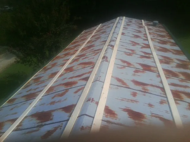 Rusted metal roof panels with new wood purlins before replacement — Storm Damage Roof Repair in Cade by Roofing Brothers
