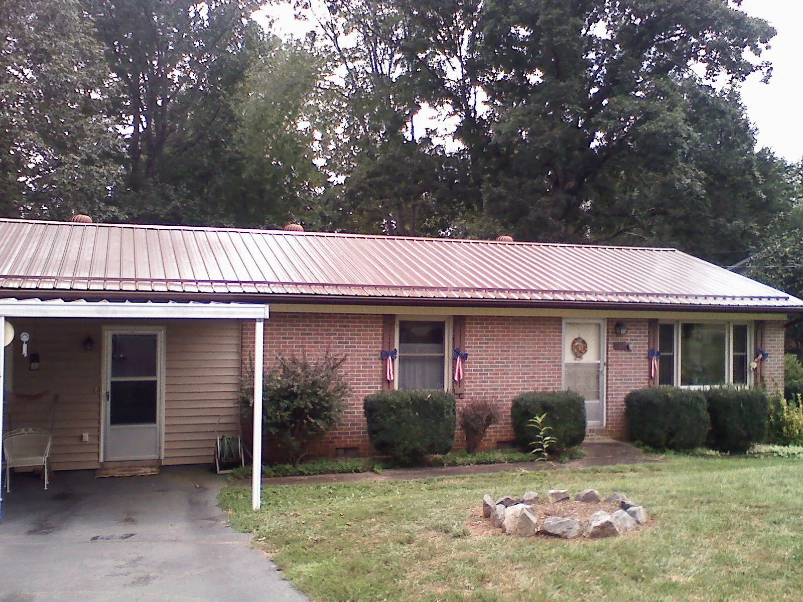 Bronze metal roof and carport on a brick ranch home — Roof Repair work by our crew in Cade